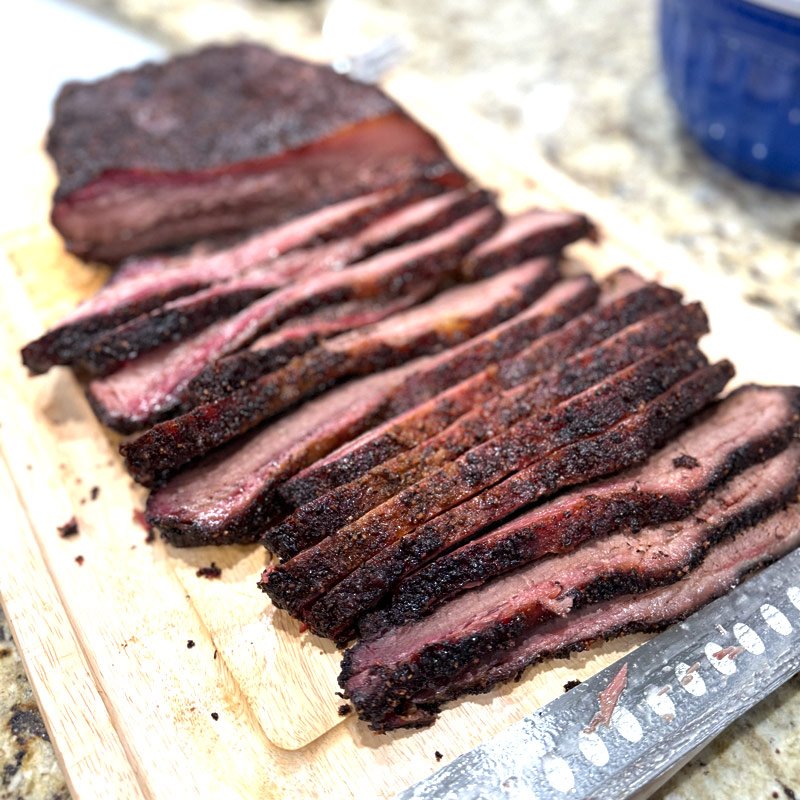 Sliced smoked brisket on a cutting board